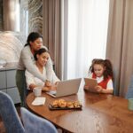 Family using a tablet together in a cozy kitchen, the room where a smart family calendar like the Cozyla Calendar+ Go lives