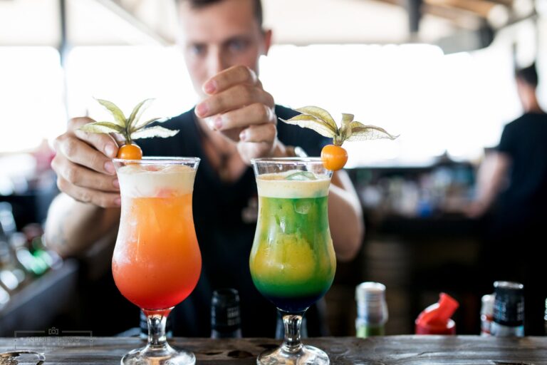 Bartender garnishing vibrant fresh cocktails at a home bar counter