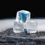 Ice cubes melting into water on a dark counter, the core problem a countertop ice maker with an insulated bin solves