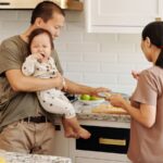 Family cooking in a modern kitchen with a toddler at counter height, illustrating toddler tower safety