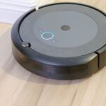 A robot vacuum cleaning a hard floor, illustrating the 2026 FCC import ban on foreign-made robot vacuums