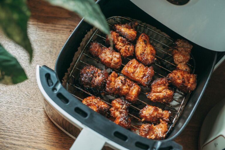 Crispy chicken pieces cooked in a modern air fryer on a kitchen counter