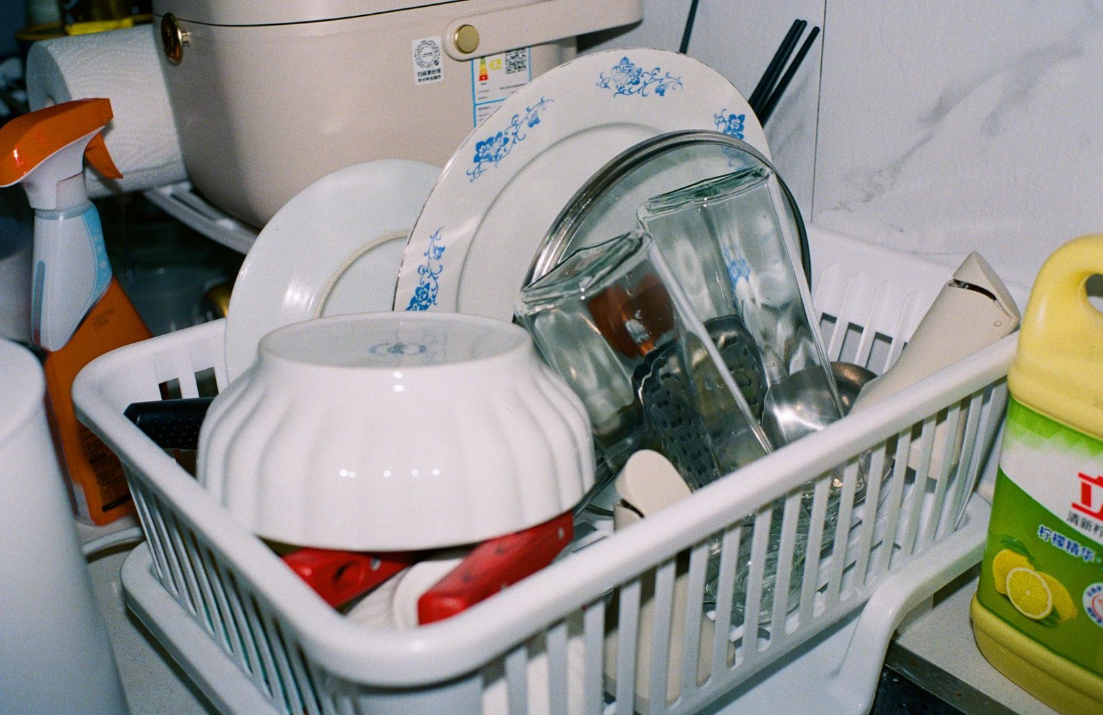 Clean plates and glasses drying inside a countertop dishwasher rack