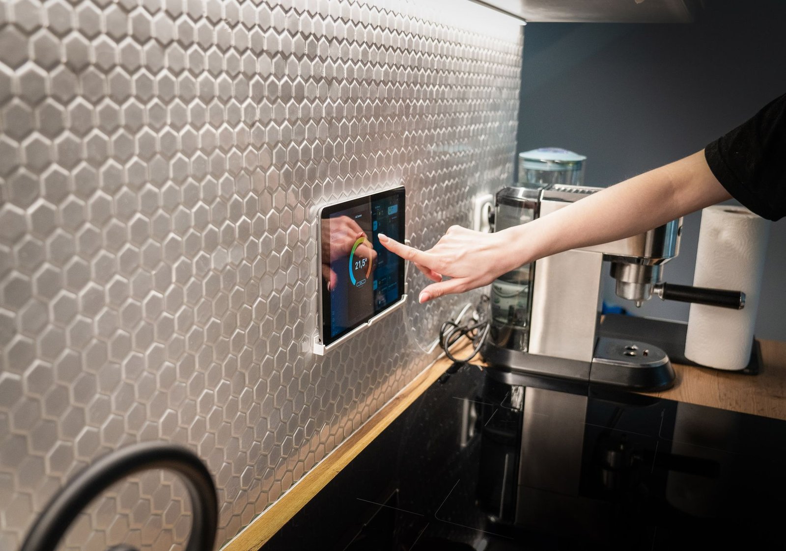 A large touchscreen smart home display panel in a modern kitchen like the Cozyla Calendar+ Go