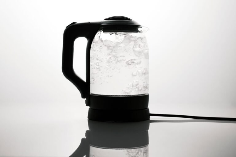 A sleek stainless electric kettle boiling water on a counter