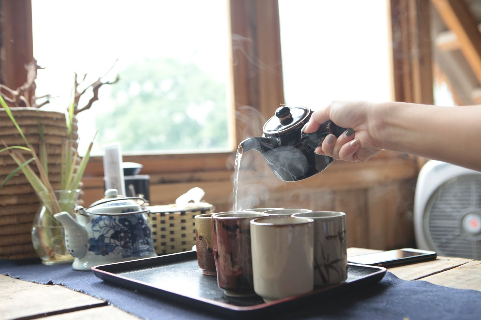 Pouring freshly boiled tea into ceramic cups