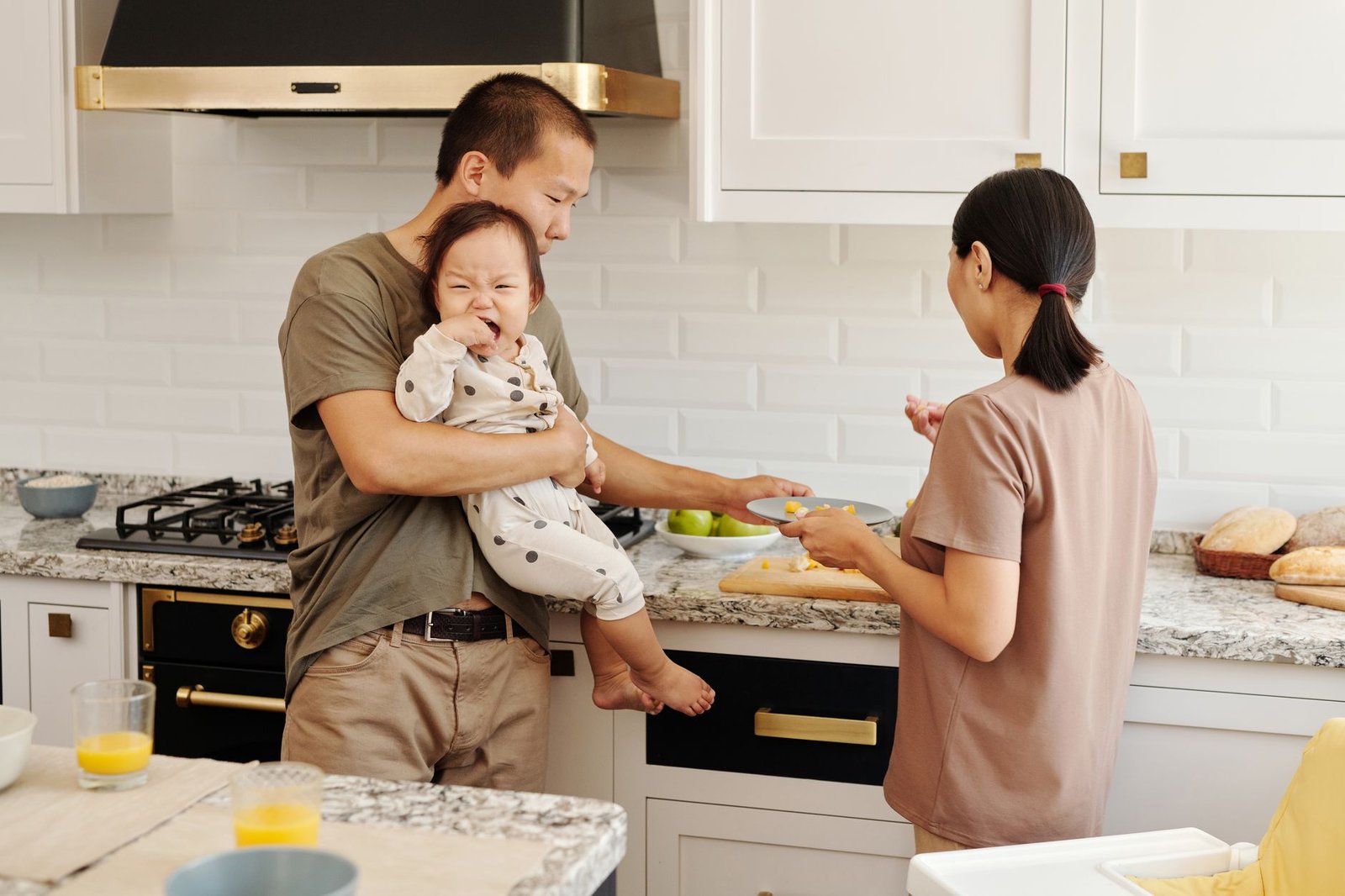 Family cooking together with a toddler at counter height in a modern kitchen