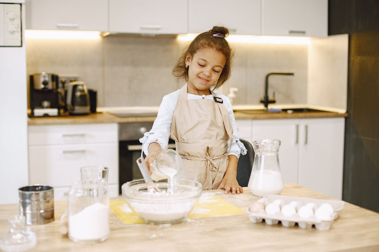 Young child in a kitchen reaching a counter, showing why a stable learning tower matters for toddler safety